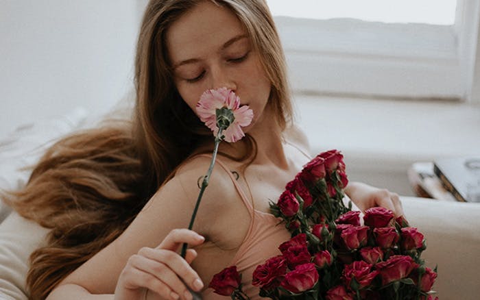 Mujer oliendo flores